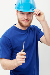 Image showing Construction worker man, screwdriver and studio portrait with smile, helmet and ready by white background. Person, handyman or contract with tools, safety and pride for job, services and maintenance