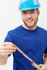 Image showing Portrait, builder and man with a hard hat, measurement tape and smile isolated on a white studio background. Face, person and construction worker with a helmet, safety and equipment with entrepreneur