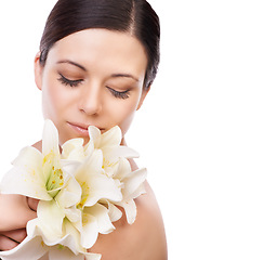 Image showing Flower, beauty and woman in studio for makeup, wellness or eco friendly cosmetics on white background space. Lily, plant or face of model with glowing skin, dermatology or floral cosmetology results