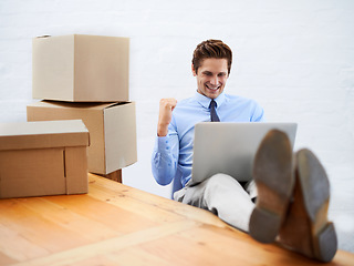 Image showing Business man, celebrate and logistics in office with fist pump, laptop and online for shipping boxes. Male person, promotion and sale on delivery distribution or dropshipping, discount and package