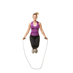 Image showing Jump, skipping rope and portrait of woman on a white background for fitness, workout and training. Sports, happy and isolated person with gym equipment for health, wellness and exercise in studio