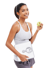 Image showing Woman, portrait and apple with scale in diet, lose weight or body goals and progress in studio. Happy model or african person and green fruit, healthy food or nutrition benefits on a white background