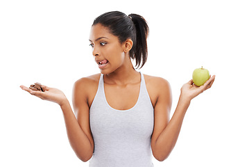 Image showing Woman, apple and chocolate in studio with diet risk, temptation and cheat day with healthy food choice or sugar in studio. Person with sweets versus green fruit in palm or detox on a white background