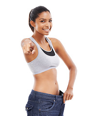 Image showing Happy woman, portrait and pants pointing in weight loss, choice or decision against a white studio background. Attractive young female person or model smile for pick or choose in health and wellness