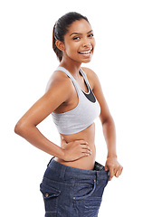 Image showing Happy woman, portrait and weight loss in diet with pants size in fitness against a white studio background. Slim young female person or model smile for thin waist, results or health and wellness