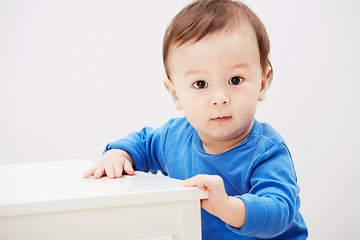 Image showing Baby, portrait and balance for walking steps in home for childhood development, safety or mockup space. Boy, kid and face or holding furniture for growing support or progress, learning or curious