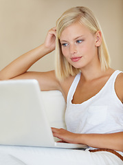 Image showing Young woman, laptop and relax on sofa with online streaming service for website, movie or social media. Person watch or reading on her computer for internet search and subscription on a couch at home