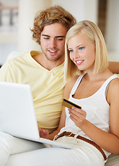 Image showing Young couple, credit card and laptop for home online shopping, loan and digital money on a sofa. Happy woman and man on computer for internet banking, easy website payment or e commerce registration