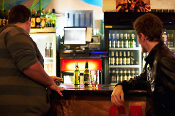Image showing Bar, alcohol and men for talking, conversation and social gathering for celebration at night. Beer, liquor and male friends waiting for service at counter for bonding, chat and relax together in pub