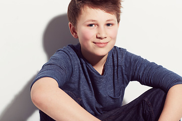 Image showing Happy, teenager and portrait of boy with fashion sitting in white background of studio. Cool, style and kid with a smile, confidence and pride in trendy outfit or relax in clothes on backdrop