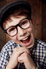 Image showing Glasses, portrait and happy for boy in funny comic and vintage fashion in eyewear by wooden background. Child, face or laughter for comedy or retro clothes, spectacles or joke for smart for vision