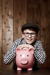 Image showing Piggy bank, smile and portrait of boy child with savings, growth or investment success in his home. Finance, learning and face of excited kid with money box for future education, funding or security
