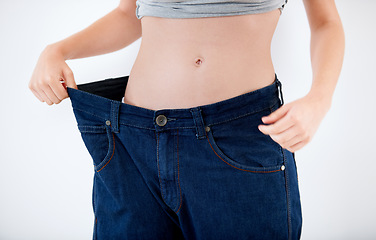 Image showing Weight, loss and woman with change in jeans, size and comparison on white background in studio. Healthy, body and person with large transformation from fitness, diet or show results in denim pants