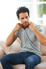 Image showing Man, sofa and take off tshirt in a house for comfort, rest or chilling on weekend, day off or vacation. Sweater, removal or male person in a living room undressing, relax and ready to be comfortable