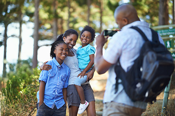 Image showing Smile, photograph and a black family hiking in the forest together for travel, tourism or adventure. Love, photography or memory with a man, woman and children in the woods or wilderness for freedom