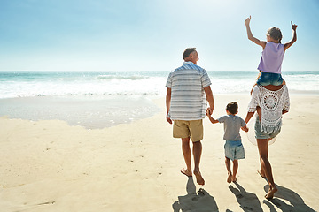 Image showing Parents, children and beach or happy summer travel sea vacation, ocean sunshine or siblings.. Man, woman and kid piggy back or behind on sand for family holiday walk or outdoor, clean air or relax