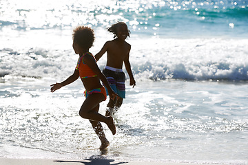 Image showing African kids, beach and playing in water at sea, smile and having fun together on summer holiday. Children, ocean and siblings, brother or sister on vacation, travel and happy family running outdoor