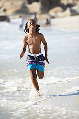 Image showing Running, black boy and happiness on beach with energy for adventure, holiday or vacation in summer. African kid, face and smile outdoor in nature for break, experience or getaway by ocean or sea