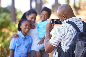 Image showing Happy black family, photography and nature for hiking, bonding or outdoor photo together. African mother, children and father or photographer smile taking picture on phone for adventure in forest