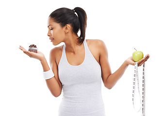 Image showing Woman, cupcake and choice or fruit decision in studio healthy, nutrition benefits or weight loss. Female person, dessert and apple in hands for balance or mockup space, wellness or white background