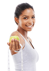 Image showing Happy woman, portrait and lose weight with a measuring tape and apple in white background or studio. Indian, model and healthy food for results in fitness, wellness and diet with nutrition and fruit