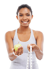 Image showing Woman, portrait and lose weight with a measuring tape and apple in white background or studio. Happy, model and healthy food for results in fitness, wellness and diet with nutrition and fruit