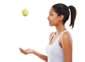 Image showing Health, diet and a woman throwing an apple in studio isolated on a white background for nutrition. Profile, fitness or exercise with a happy young athlete catching a natural green fruit for wellness