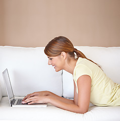 Image showing Woman, smile or typing on laptop at sofa to update blog post, social media or digital subscription for remote work. Profile, happy freelancer or computer for online shopping, email or relax at mockup