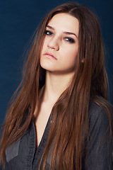 Image showing Portrait, beauty and a serious young woman in studio on a dark background with an intense attitude. Face, skincare and makeup with a fierce model looking confident in cosmetic wellness or haircare