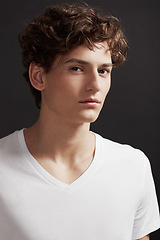 Image showing Young man, portrait and serious with model, casual fashion and gen z style with confidence in studio. Youth, hipster and male person with cool, trendy and minimalist clothes with black background