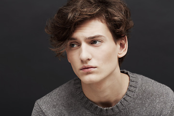 Image showing Young man, thinking and serious with model, casual fashion and gen z style with confidence in studio. Youth, hipster and male person with cool, trendy and minimalist clothes with black background