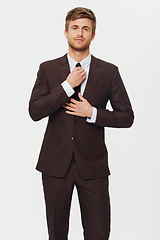 Image showing Portrait, business and a man getting ready in a suit for his job opportunity in studio on white background. Corporate fashion, work and a confident young person dressing in a tie for a formal career