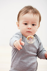 Image showing Baby, bubbles and playing game for fun childhood development, curious wondering or education. Kid, growth and mockup space for learning progress or sensory, coordination skill or youth entertainment