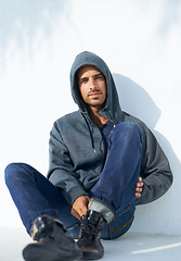 Image showing Fashion, serious and portrait of man by a wall with casual, cool and stylish outfit with confidence. Handsome, young and young male person with trendy style with jeans and hoodie by white background.