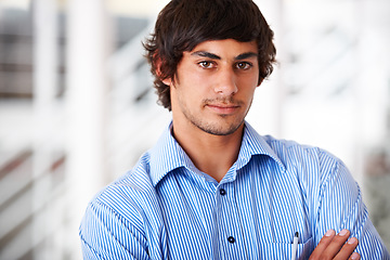 Image showing Portrait, confident and a business man arms crossed in his office for a professional company internship. Face, serious and shirt with a young employee standing in his design agency workplace