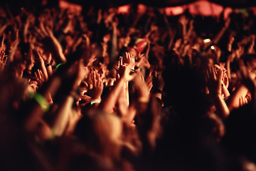 Image showing People, hands and crowd for music, festival and outside with arms raised for dancing, movement or enjoyment. Audience, concert and excitement with dj, band or singer with red, lighting and equipment