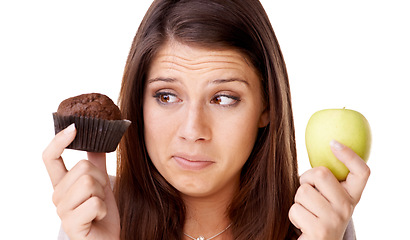 Image showing Face, decision and apple or muffin with a woman in studio isolated on a white background for food choice. Doubt, diet or nutrition with a confused young person holding fruit and dessert options