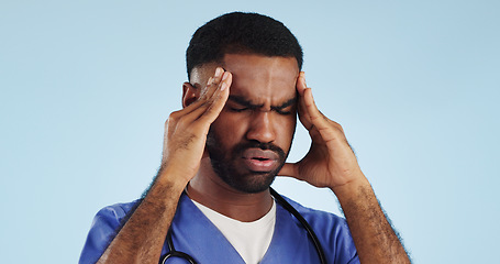 Image showing Doctor, dizzy or man in studio with headache, head pain or fatigue in medical healthcare crisis or emergency. Depression, face or tired male nurse with burnout, migraine or stress on blue background