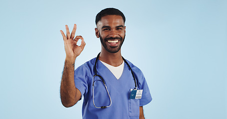 Image showing Happy man, okay or portrait of doctor with smile, pride or confidence isolated on blue background. Wellness, perfect or healthcare worker with approval sign, success or yes hand gesture in studio