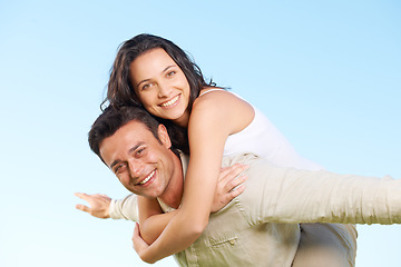 Image showing Happy couple, portrait and piggyback with love, marriage and enjoying a break on holiday, smile and funny. Playful, vacation and honeymoon for having fun, carefree and romantic relationship
