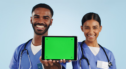 Image showing Doctor, portrait and tablet with green screen for healthcare advertising against a blue studio background. Man and woman, nurse or medical team showing technology display, chromakey or mockup space