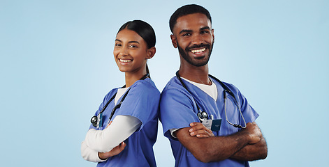 Image showing Portrait, healthcare and arms crossed with a medicine team in studio on a blue background for trust. Medical, smile or wellness with a young man and woman nurse looking confident for treatment