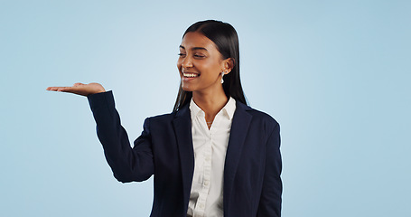 Image showing Happy businesswoman, studio or palm for investment deal, financial offer or product mockup space. Hand, smile or proud Indian corporate worker on blue background marketing, advertising or finance