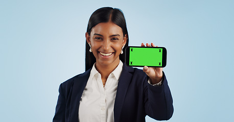 Image showing Happy business woman, phone and green screen for advertising against a blue studio background. Portrait of female person or employee smile showing mobile smartphone display, chromakey or mockup space