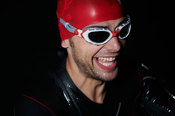 Image showing A triathlete finds serene rejuvenation in a lake, basking in the tranquility of the water after an intense training session