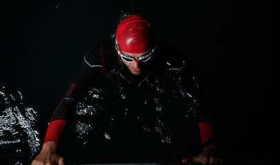 Image showing A triathlete finds serene rejuvenation in a lake, basking in the tranquility of the water after an intense training session