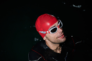 Image showing A triathlete finds serene rejuvenation in a lake, basking in the tranquility of the water after an intense training session