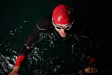 Image showing A triathlete finds serene rejuvenation in a lake, basking in the tranquility of the water after an intense training session