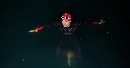 Image showing A triathlete finds serene rejuvenation in a lake, basking in the tranquility of the water after an intense training session