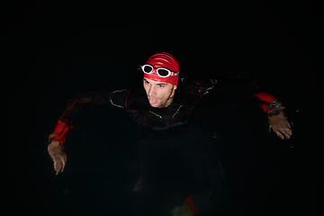 Image showing A triathlete finds serene rejuvenation in a lake, basking in the tranquility of the water after an intense training session